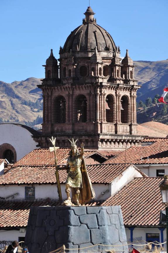 Estátua do Inca e torre de Igreja em Cusco, no Peru